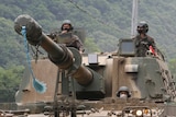 South Korean army soldiers ride a howitzer tank during a training exercise near the border with North Korea.