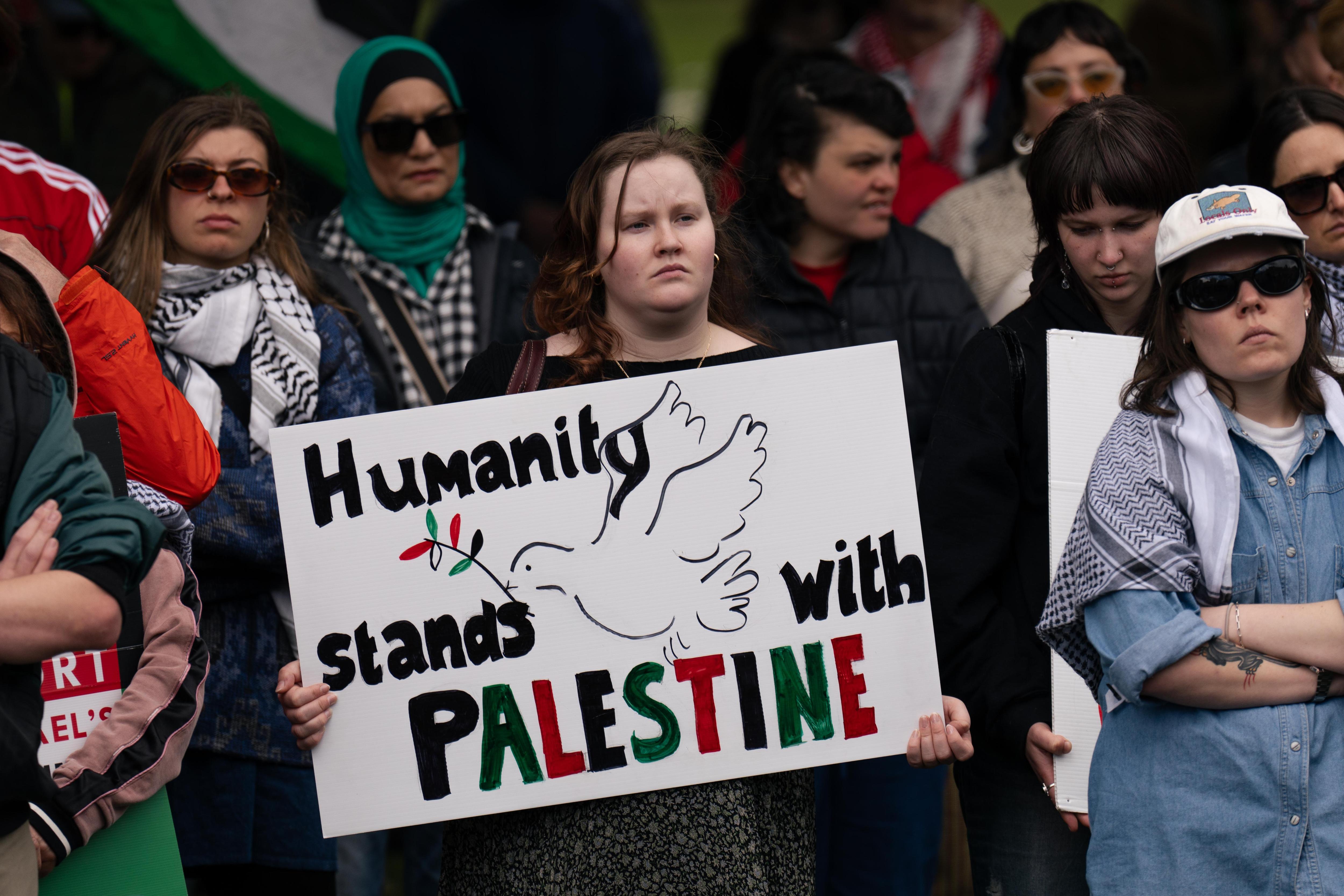 Woman holds sign saying "Humanity stands with Paletine" at Hobart pro-Palestinian march
