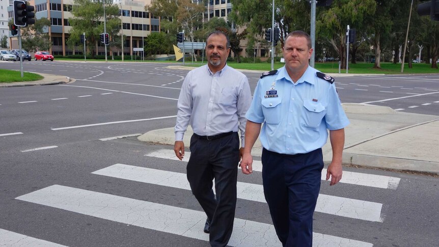Sergeant Rod Anderson and Roads ACT's Rifaat Shoukrallah cross at one of the intersections under focus.