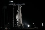 A SpaceX Falcon 9 rocket sits on the launchpad at Kennedy Space Center in the early morning