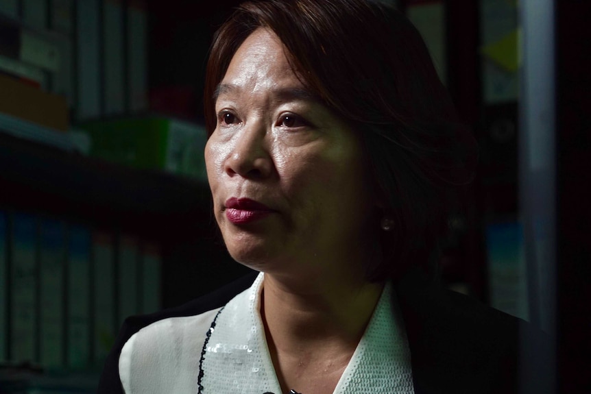 A close photo of Priscilla Leung, looking serious against a dark background.