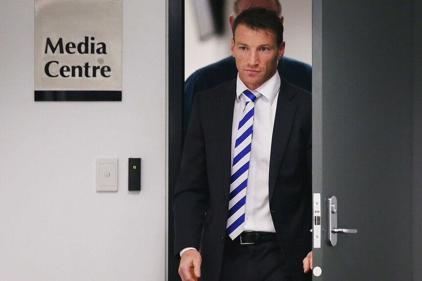 The Kangaroos' Brent Harvey leaves the AFL tribunal after being banned for three matches.