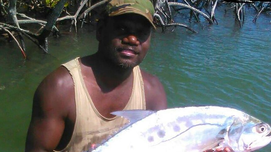 A photo of Tiwi Bombers footballer holding a large fish.