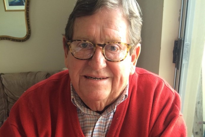 Keith wearing a red jumper and spectacles, looking into the camera.