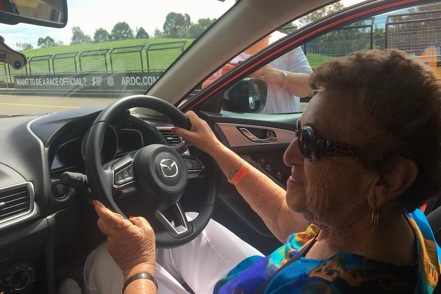 Lilly Skurnik in the driver's seat of a car.