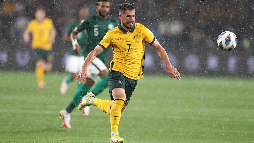 Mathew Leckie runs towards the ball as rain falls