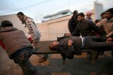 A wounded Palestinian man is carried on a stretcher into a hospital in Rafah