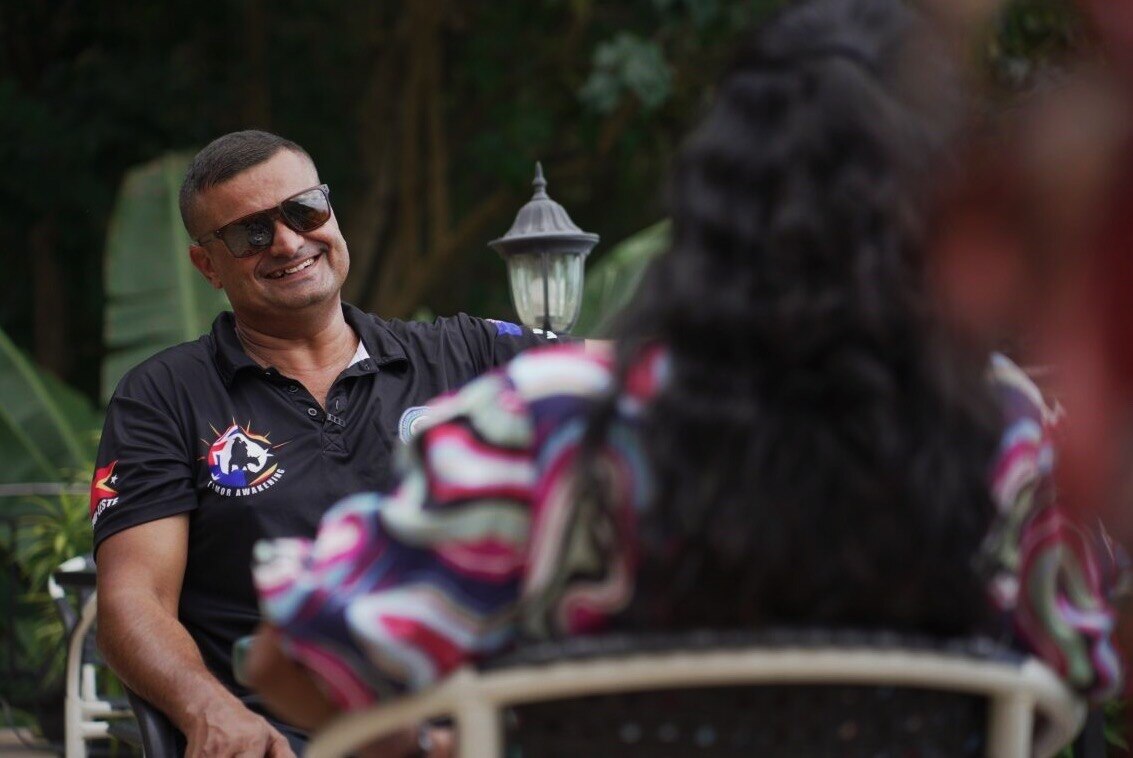 Michael smiles sitting across from his wife. 