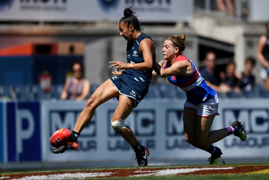 Darcy Vescio is tackled by Hannah Scott as she scores a goal during the round 5 AFLW match.