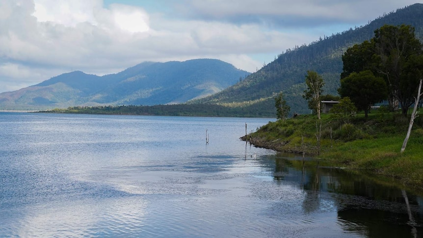 A beautiful lake with clear blue water and lush green banks.