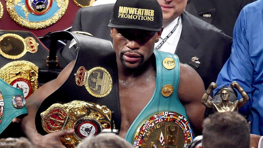 Floyd celebrates with the belts