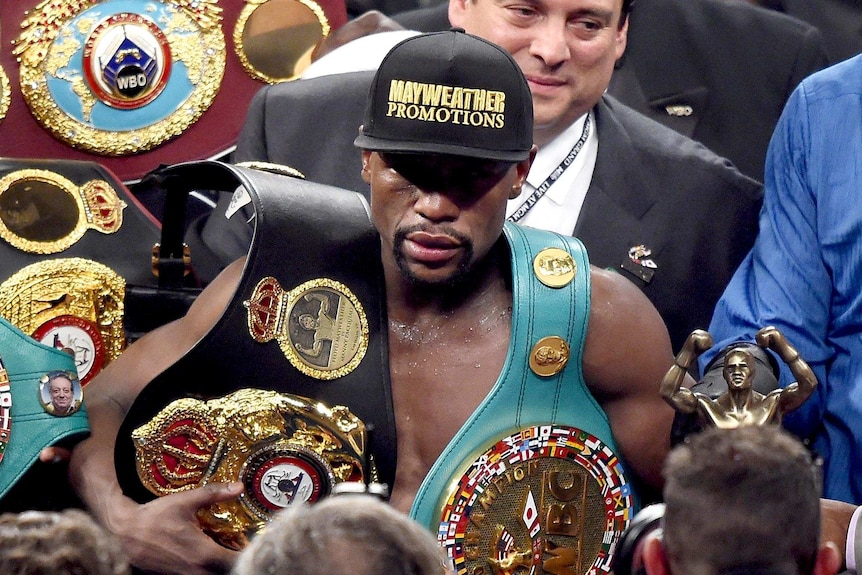 Floyd celebrates with the belts
