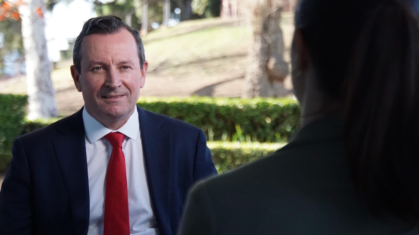Mark McGowan smiling pictured over the shoulder of a reporter