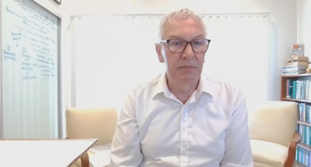 Hombre sentado en una habitación con una camisa blanca