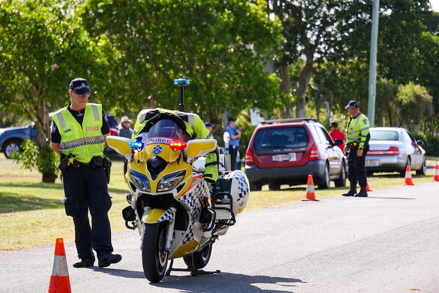 A police officer sets up a road block for the funeral.