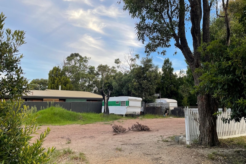 Distant caravans perched on vacant block of land 