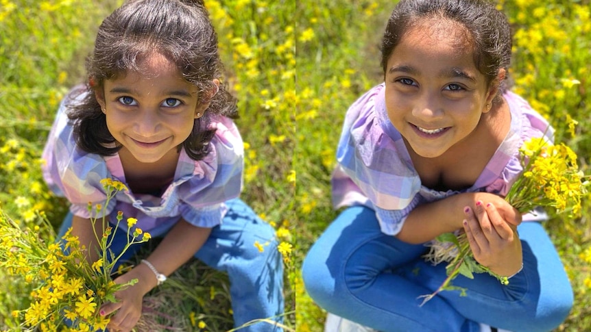 Kopika and Tharnicaa smiling, sitting in a field of green and yellow flowers.