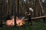 A Ukrainian soldier fires an RPG in a forest area.