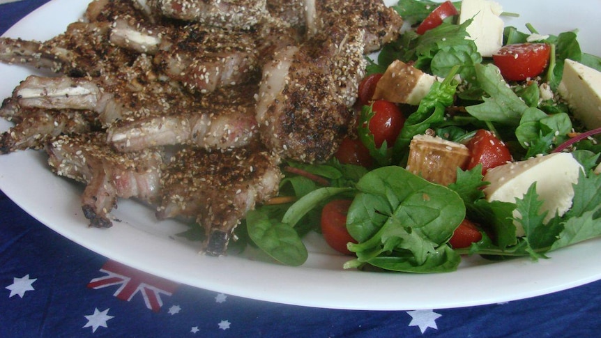 A plate loaded with lamb chops and salad.