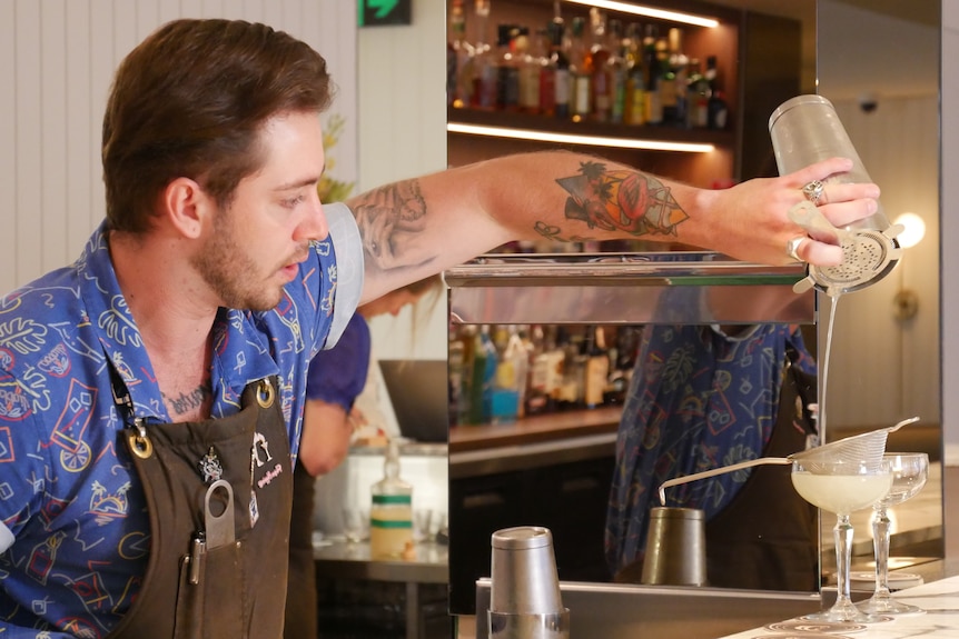 un homme versant des boissons dans un bar