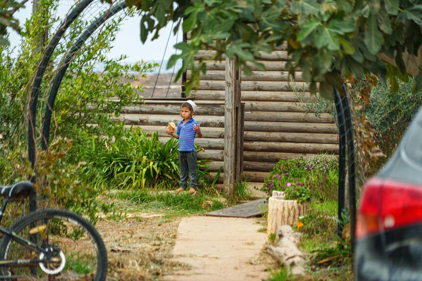 A child eating a snack in a garden 