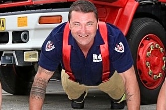 Man in uniform doing a pushup smiling