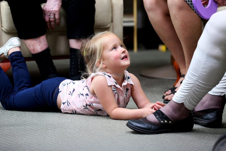 Four-year-old Hannah looks up at an adult on the ABC TV series Old People's Home For 4 Year Olds.