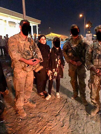 Hasina Safi at Kabul Airport soldiers and a young woman who's faces are obscured.
