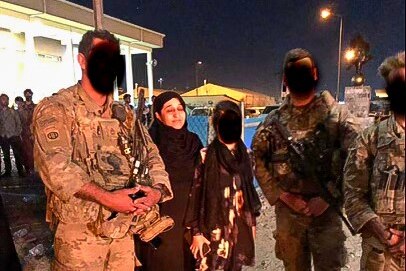 Hasina Safi at Kabul Airport soldiers and a young woman who's faces are obscured.