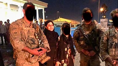 Hasina Safi at Kabul Airport with soldiers and a young woman whose faces are obscured.