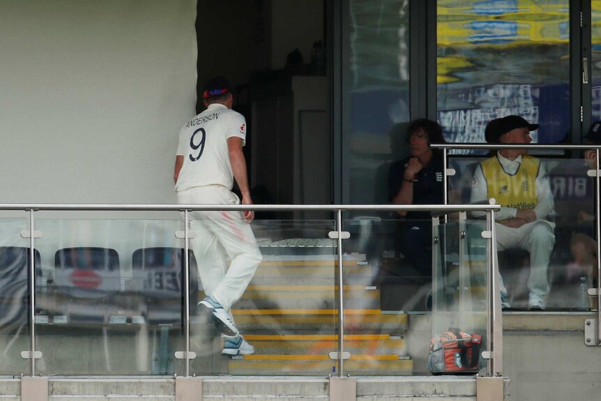 An injured bowler walks up the steps into the dressing room during an Ashes Test.
