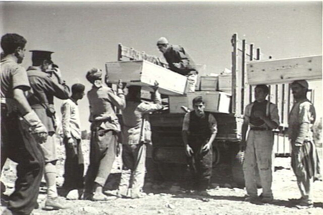 soldiers loading coffin into truck