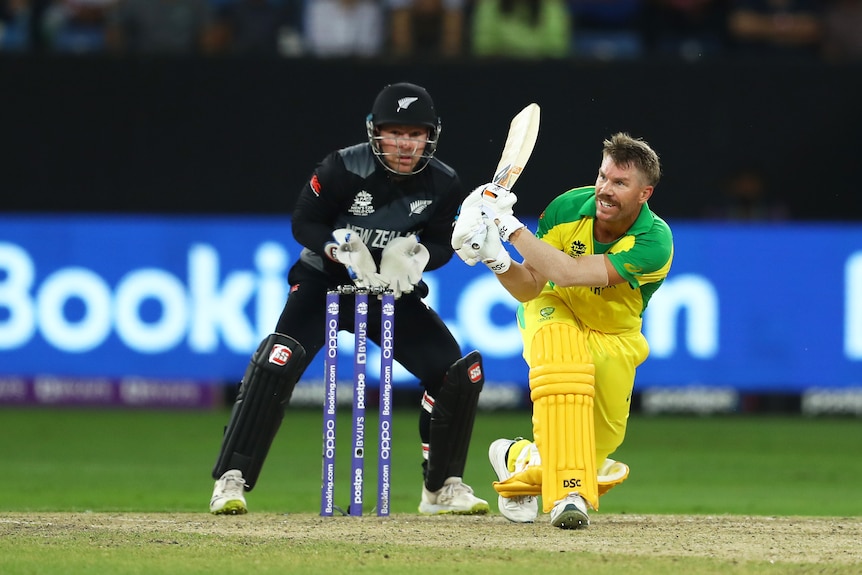 An Australian batsman whips the ball away on the leg side as the New Zealand wicketkeeper watches in the T20 World Cup final. 