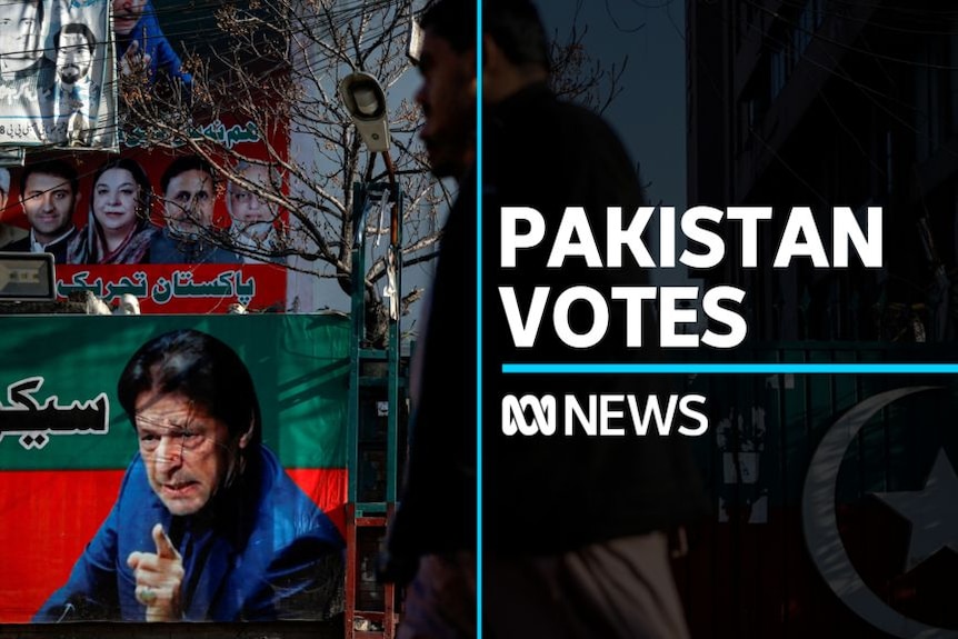 Pakistan Vote: Man walks in front of campaign poster featuring Imran Khan