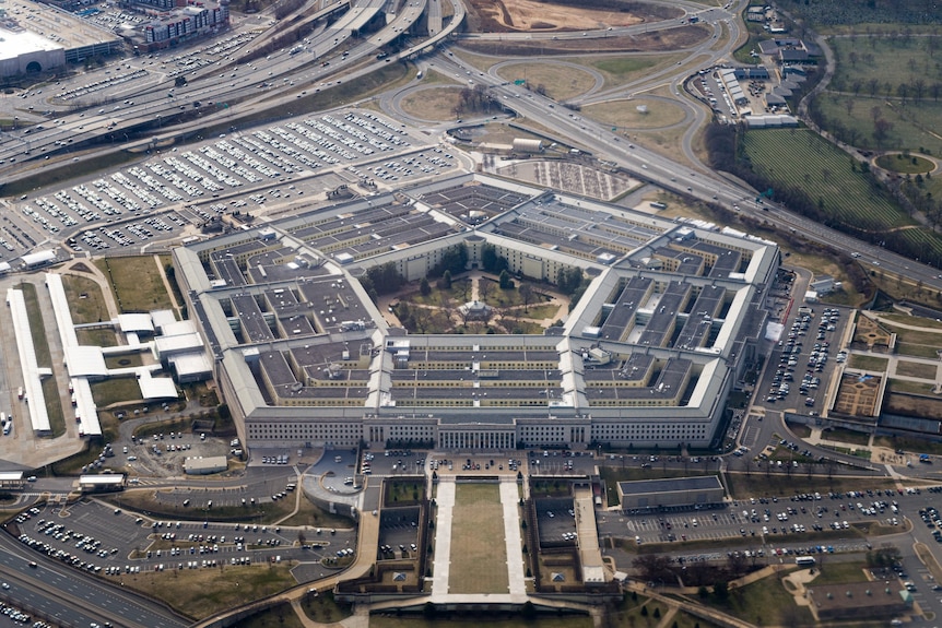 An aerial shot of the Pentagon — a large, five-sided office building with carparks