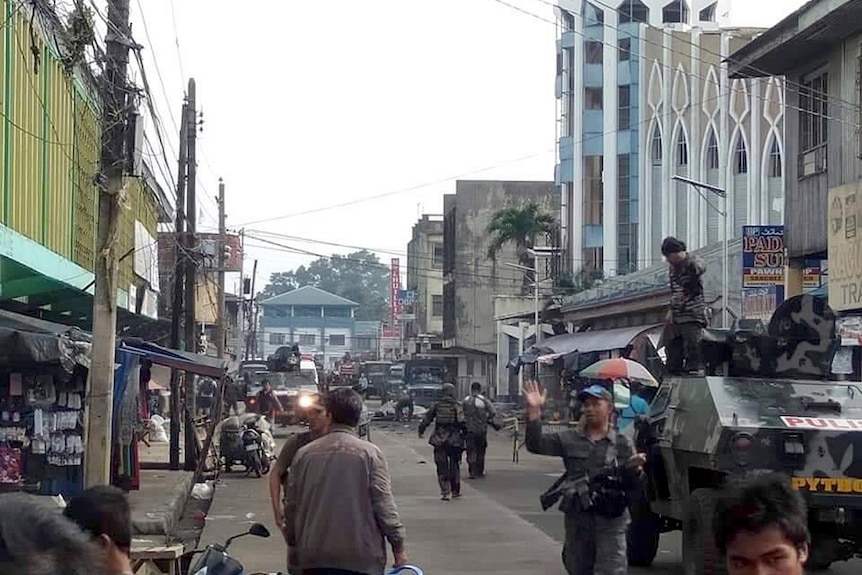 Soldiers and police secure a main street.
