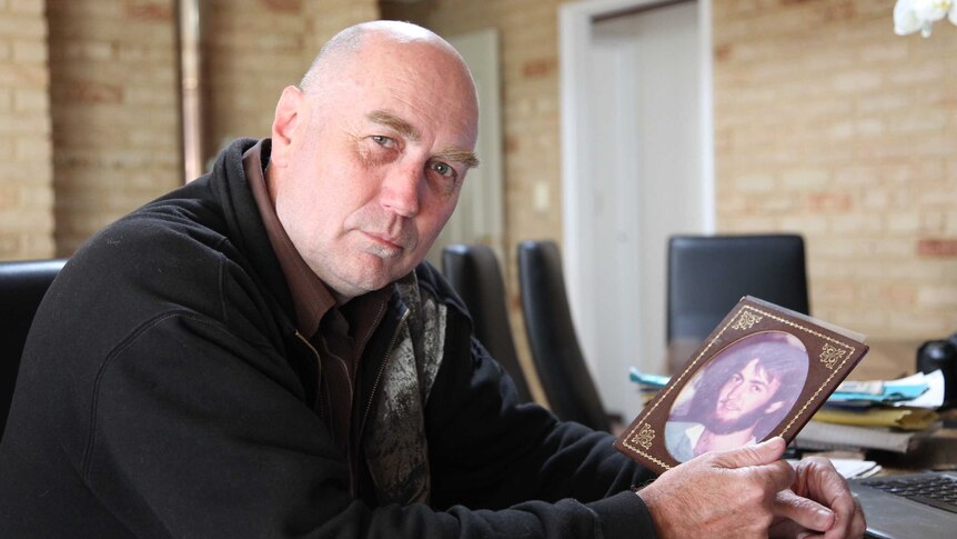 Mark Jones sits with a picture of his brother Tony Jones, who disappeared in 1982.