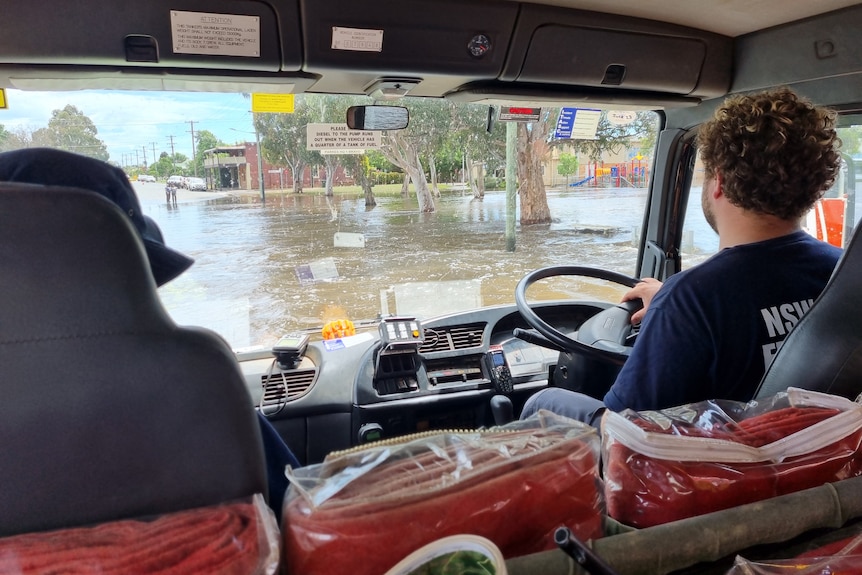 An emergency services worker drives a vehicle through flooded North Forbes. 