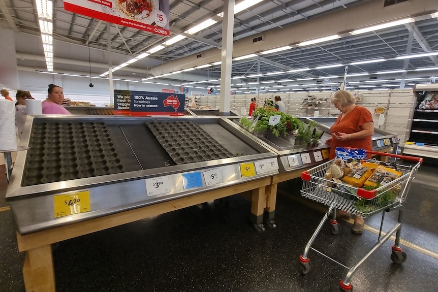 Shelves stripped bare in a Coles supermarket.