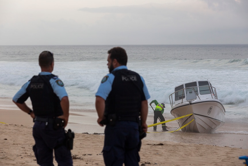 police secure an empty boat on a beach