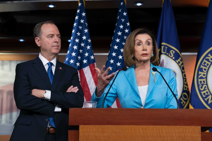 Nancy Pelosi and Adam Schiff speak from behind a speakers stand.