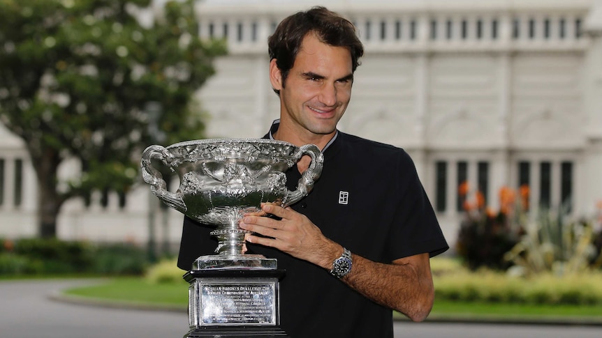 Switzerland's Roger Federer poses with the Australian Open trophy in Melbourne on January 30, 2017.