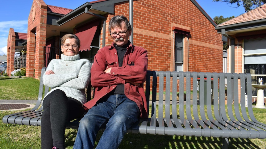 Two people, a man and a woman are sitting outside their units in Morwell.