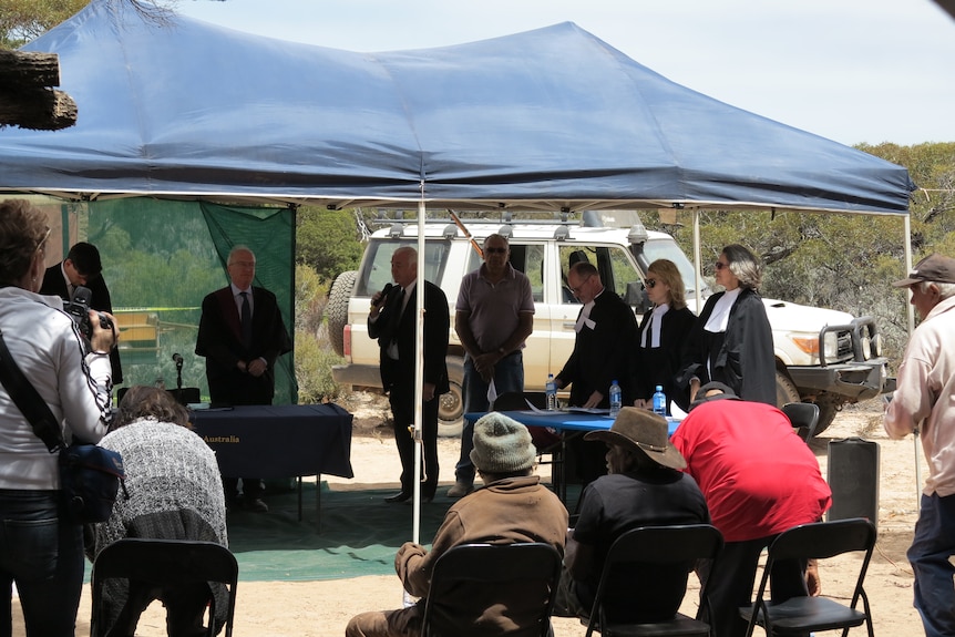 Representatives from the Federal Court of Australia standing under a tent with traditional owners of the Nullarbor. 