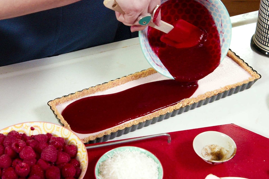Annabel Crabb pours raspberry sauce over the Iced Vo-Vo tart.
