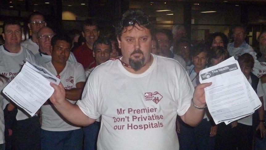 A hospital worker wears a t-shirt saying 'Mr Premier Don't Privatise our hospitals'
