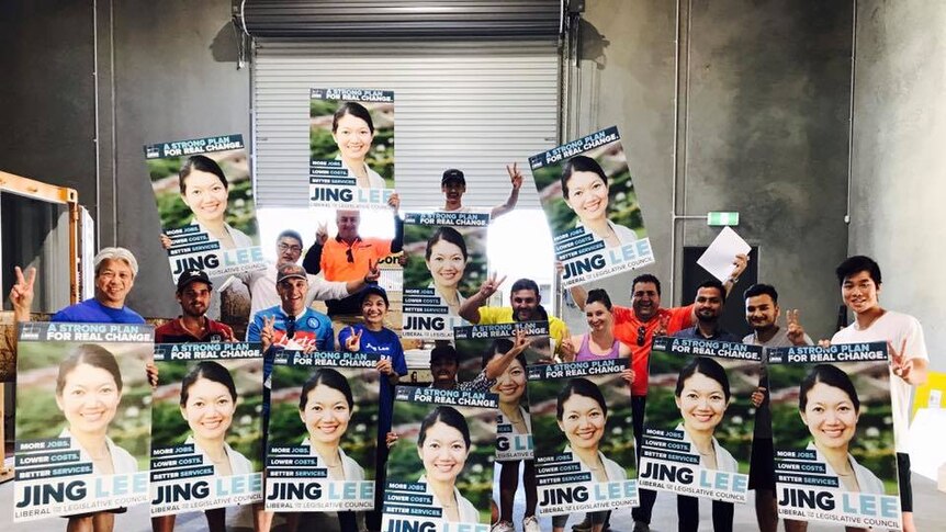 Supporters of SA Liberal candidate Jing Lee hold posters.