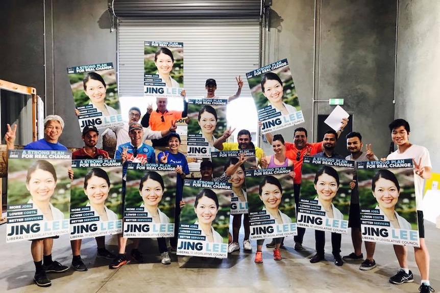 Supporters of SA Liberal candidate Jing Lee hold posters.