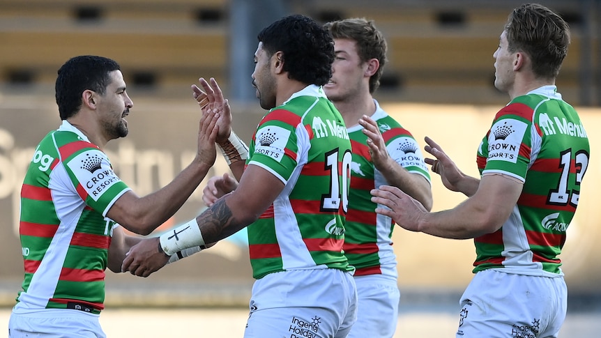 Four South Sydney NRL players celebrate a try against the Wests Tigers.