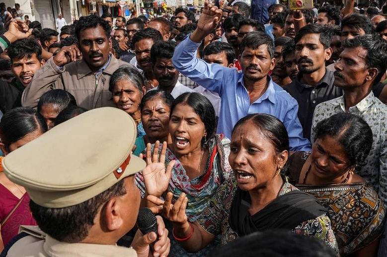 Demonstrators argue with a police officer in India.